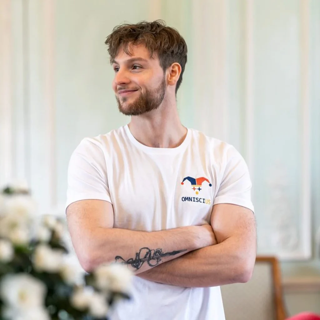Photo du t-shirt blanc brodé avec le Joker Omniscius. Porté par Romain